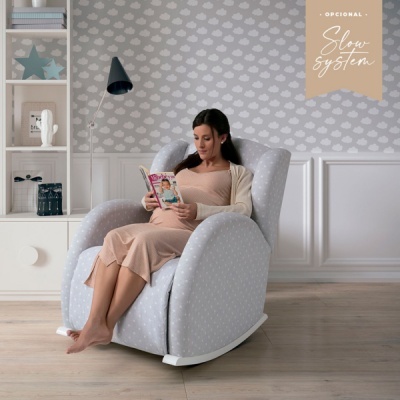 Cadeira de baloiço cinzenta com padrão de pontos brancos numa sala moderna com decoração neutra