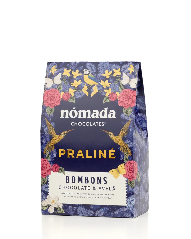 Bombons Praliné Nómada 100Gr Embalagem azul escura de bombons Praliné da Nómada com flores, borboletas e pássaros