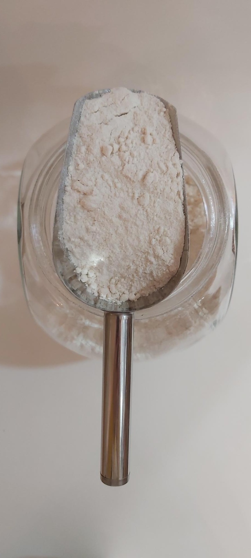 Farinha de Arroz GRANEL Colher metálica cheia de farinha branca dentro de frasco transparente