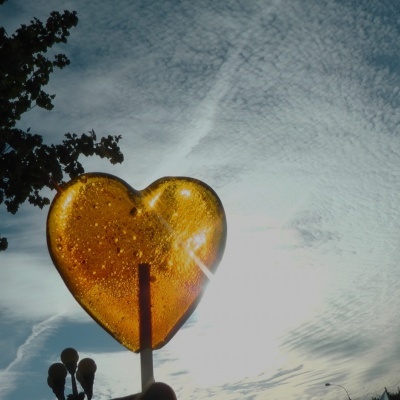 Pirulito coração âmbar translúcido com bolhas ao sol