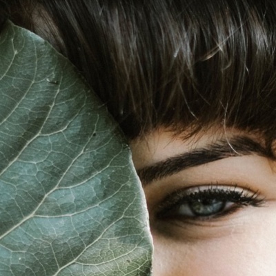 Rosto protegido por folha verde com textura detalhada