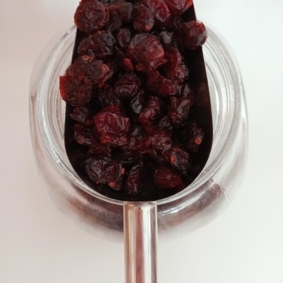 Frasco de vidro com frutos secos vermelhos em concha metálica