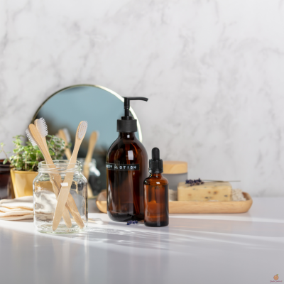 Produtos de higiene pessoal em vidro âmbar e escovas de dentes de madeira sobre bancada branca