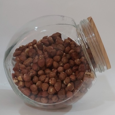 Frasco de vidro com tampa de madeira cheio de avelãs