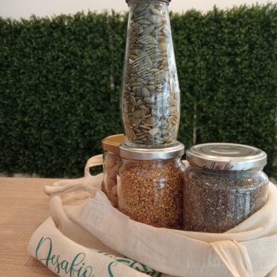 Frascos de vidro com sementes e bolsa de tecido com texto Desafio Saudável