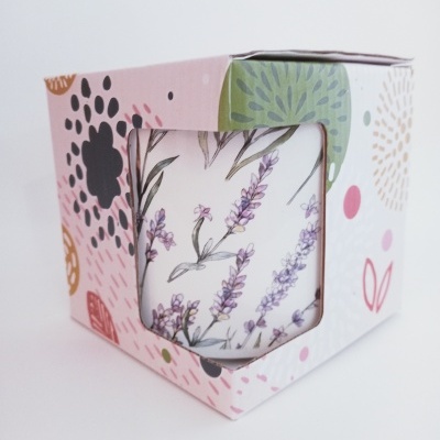 Vela decorativa com padrão de flores de lavanda numa caixa colorida com motivos florais.