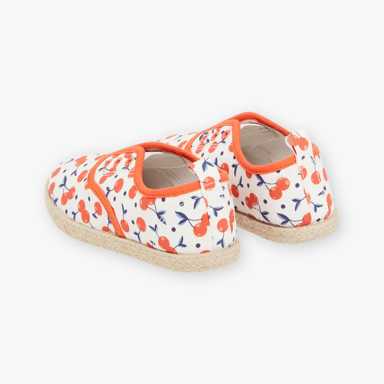 Sapatos de criança com padrão de cerejas vermelhas e folhas azuis sobre fundo branco