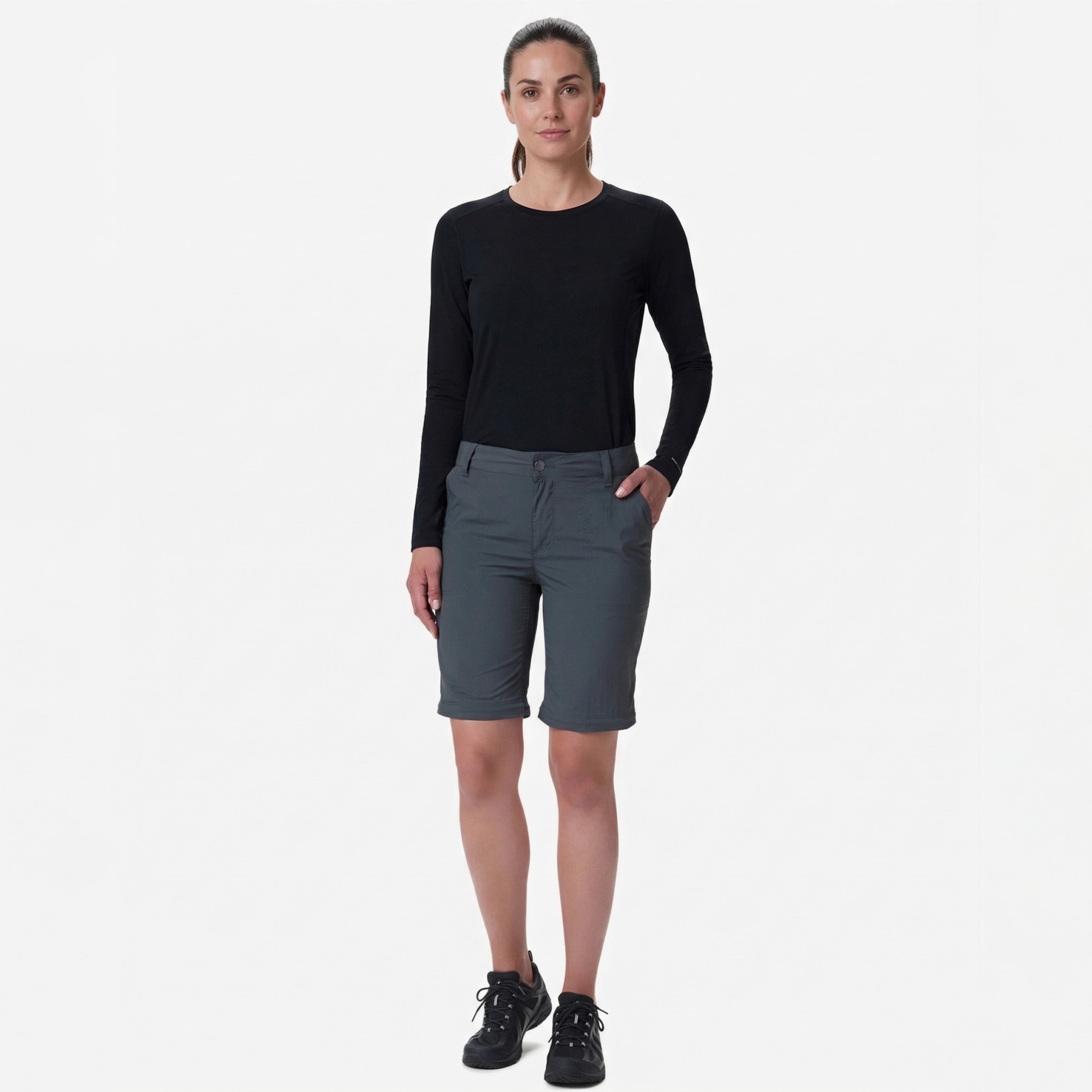 Mulher com t-shirt preta e calções cinzentos em fundo branco