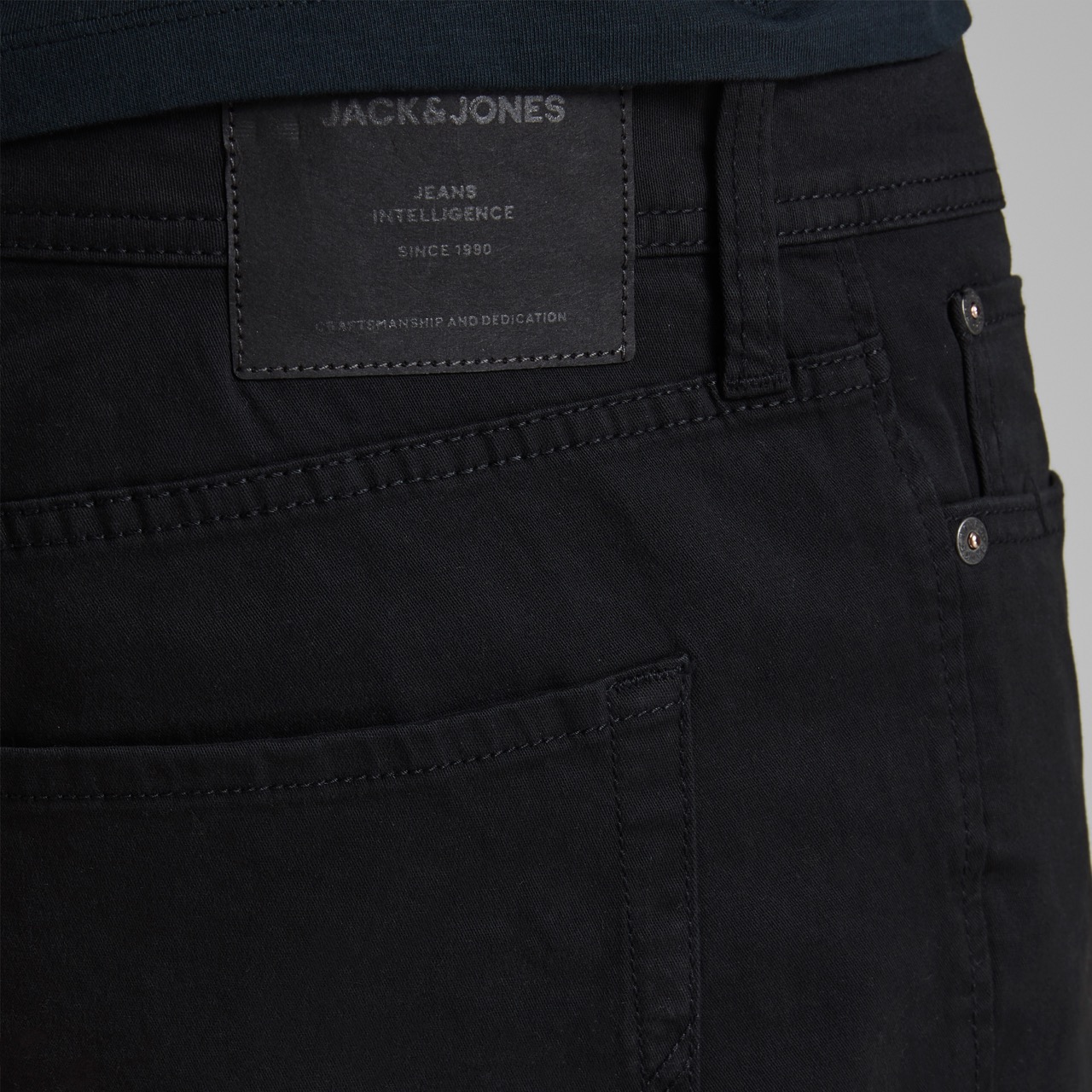 Detalhe de calças pretas com etiqueta Jack&Jones e bolsos