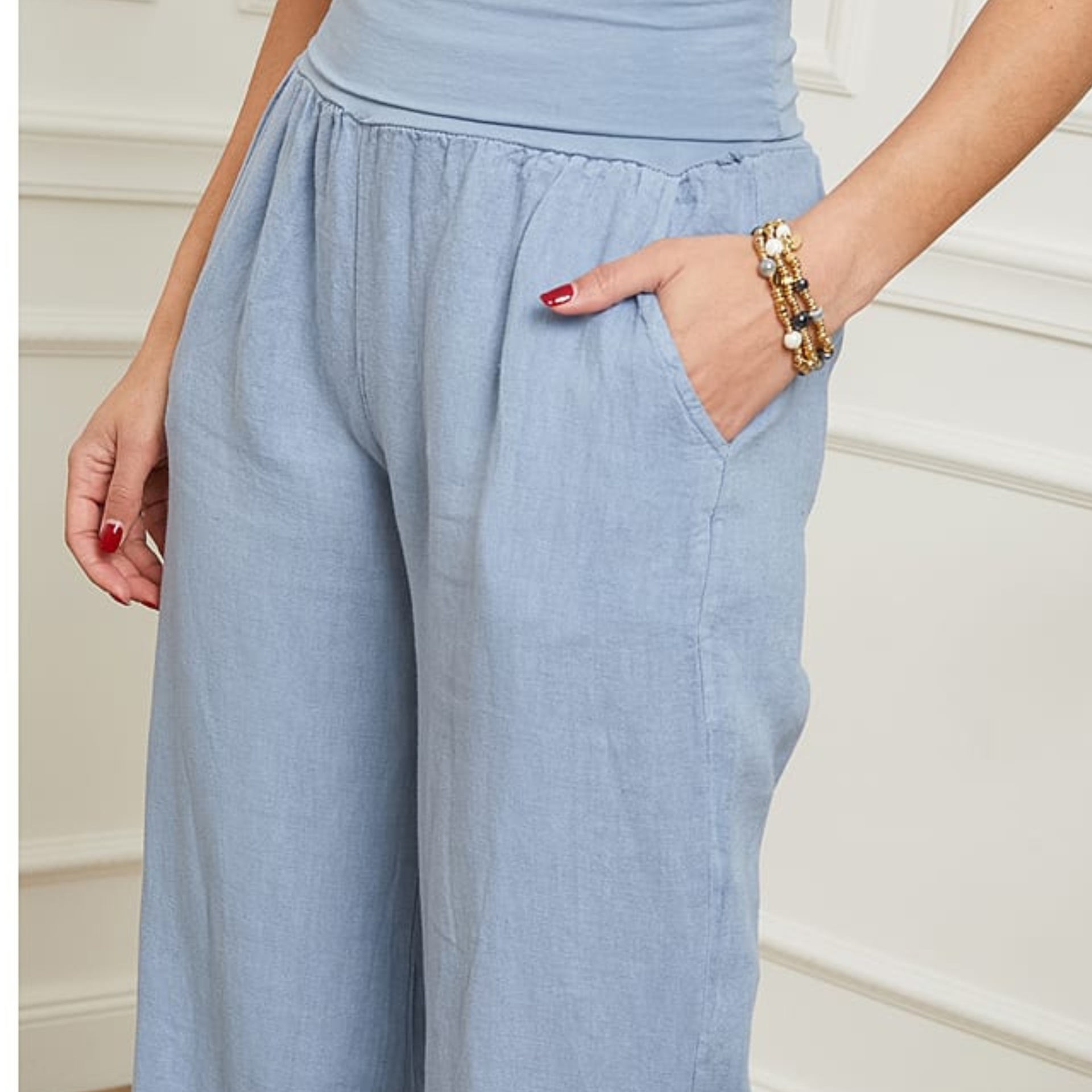 Calças largas azul claro com bolso lateral e cós elástico.