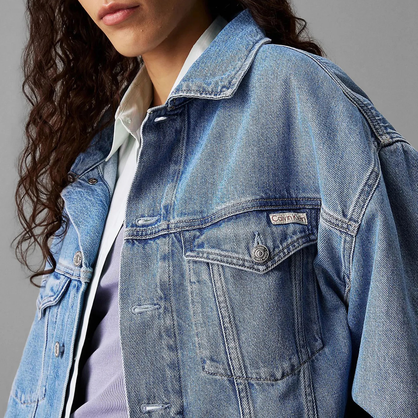 Casaco de ganga azul claro com etiqueta Calvin Klein no bolso