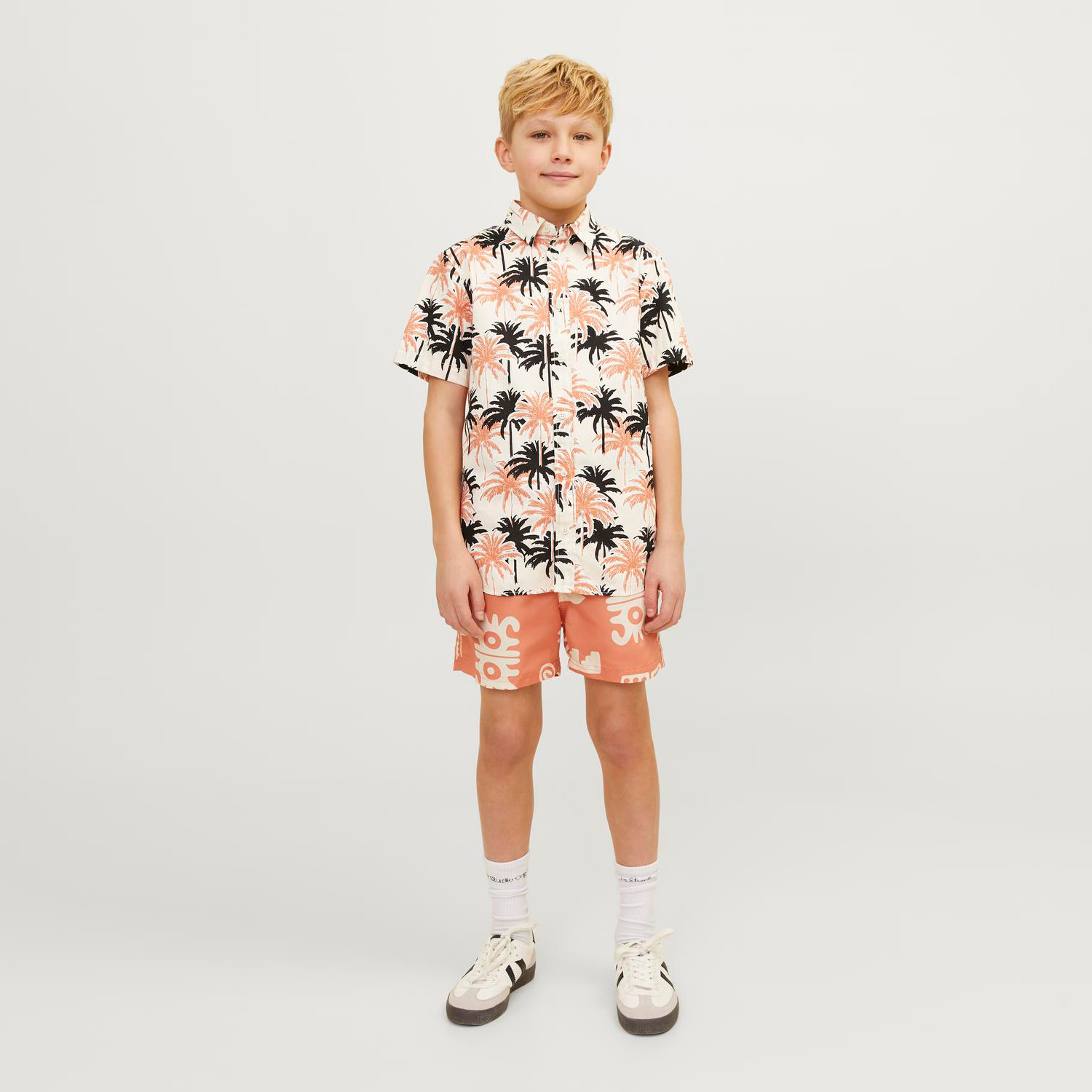 Camisola infantil estampada de palmeiras e calções coral com padrões brancos