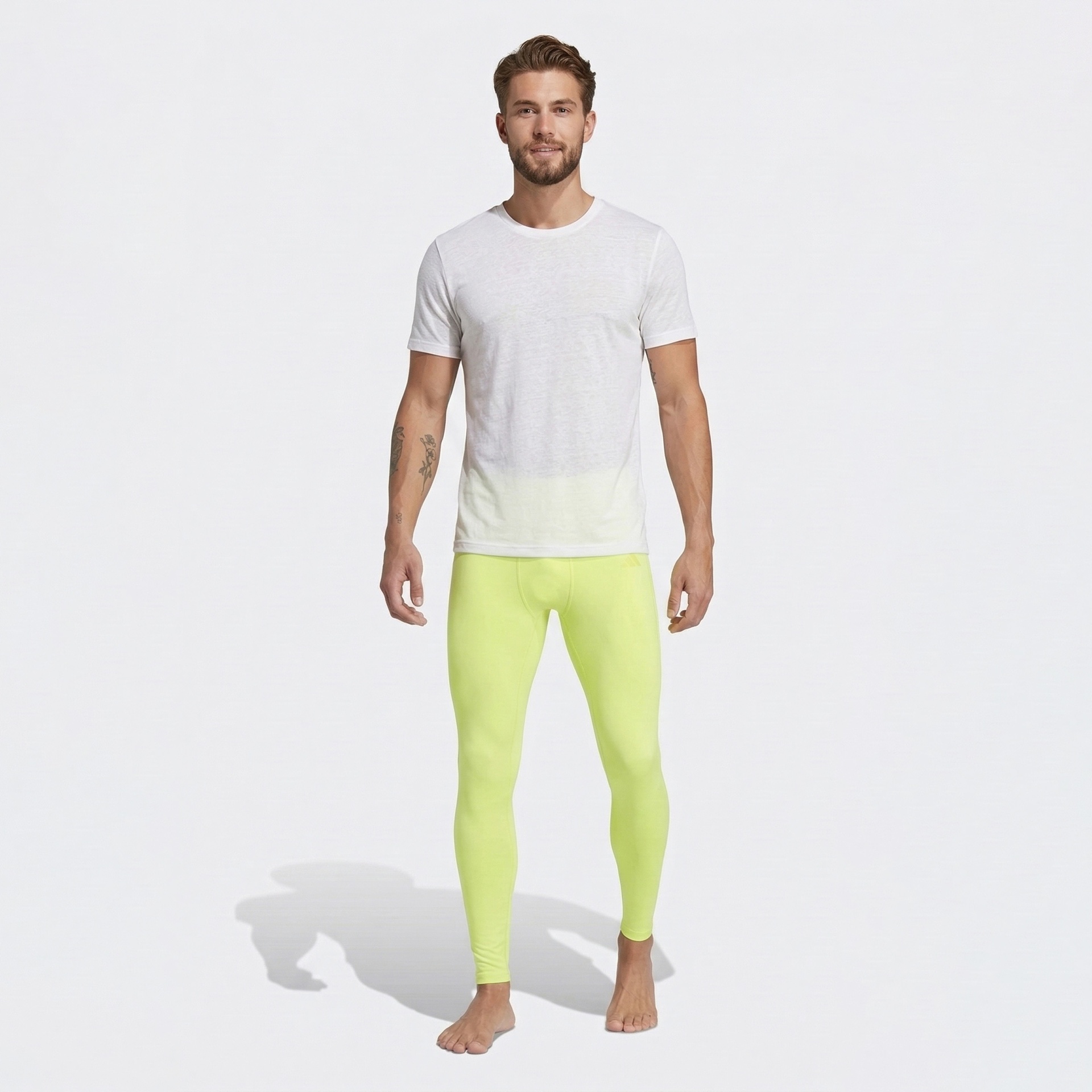 Homem de t-shirt branca e leggings amarelo-limão em fundo branco