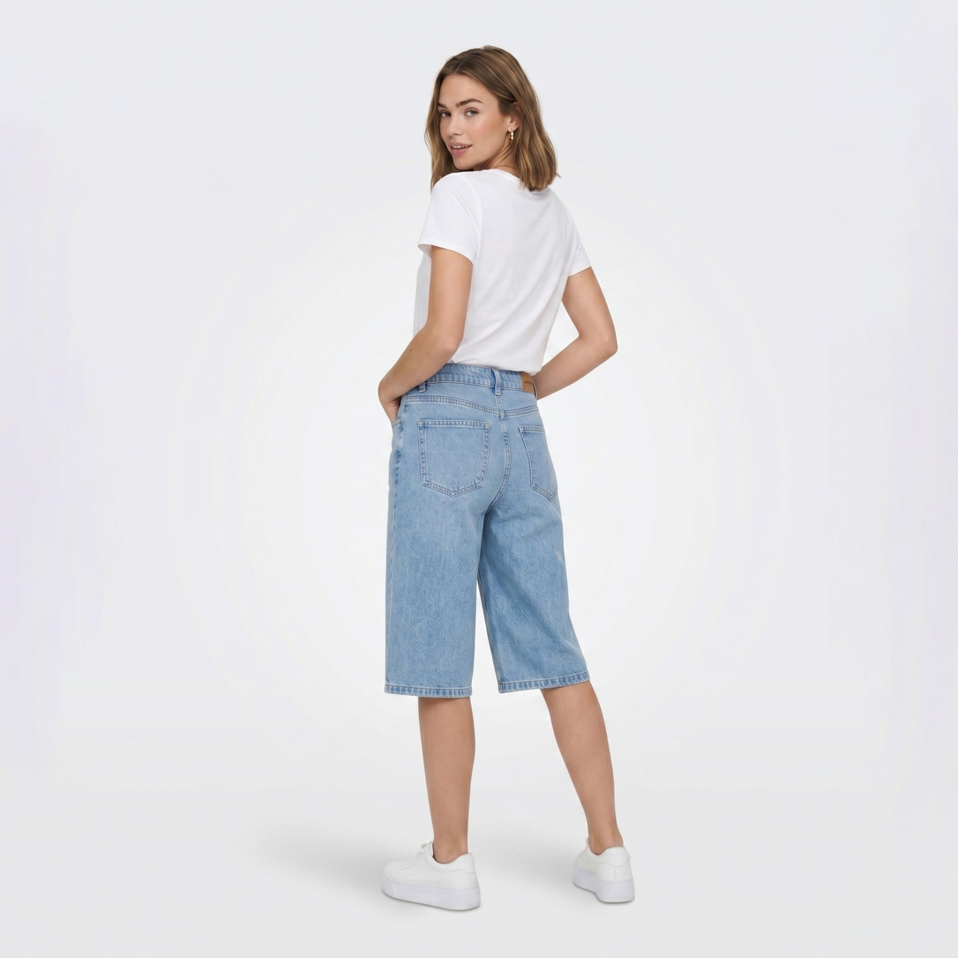 Mulher com t-shirt branca e calções de ganga azuis claros