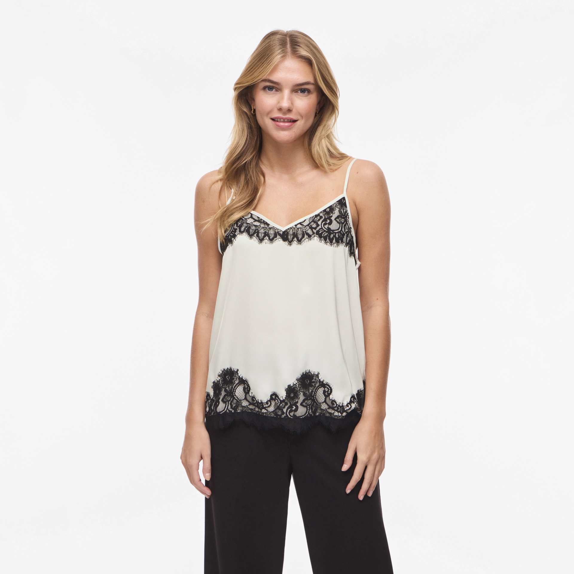 Top branco com renda preta usado por mulher loira