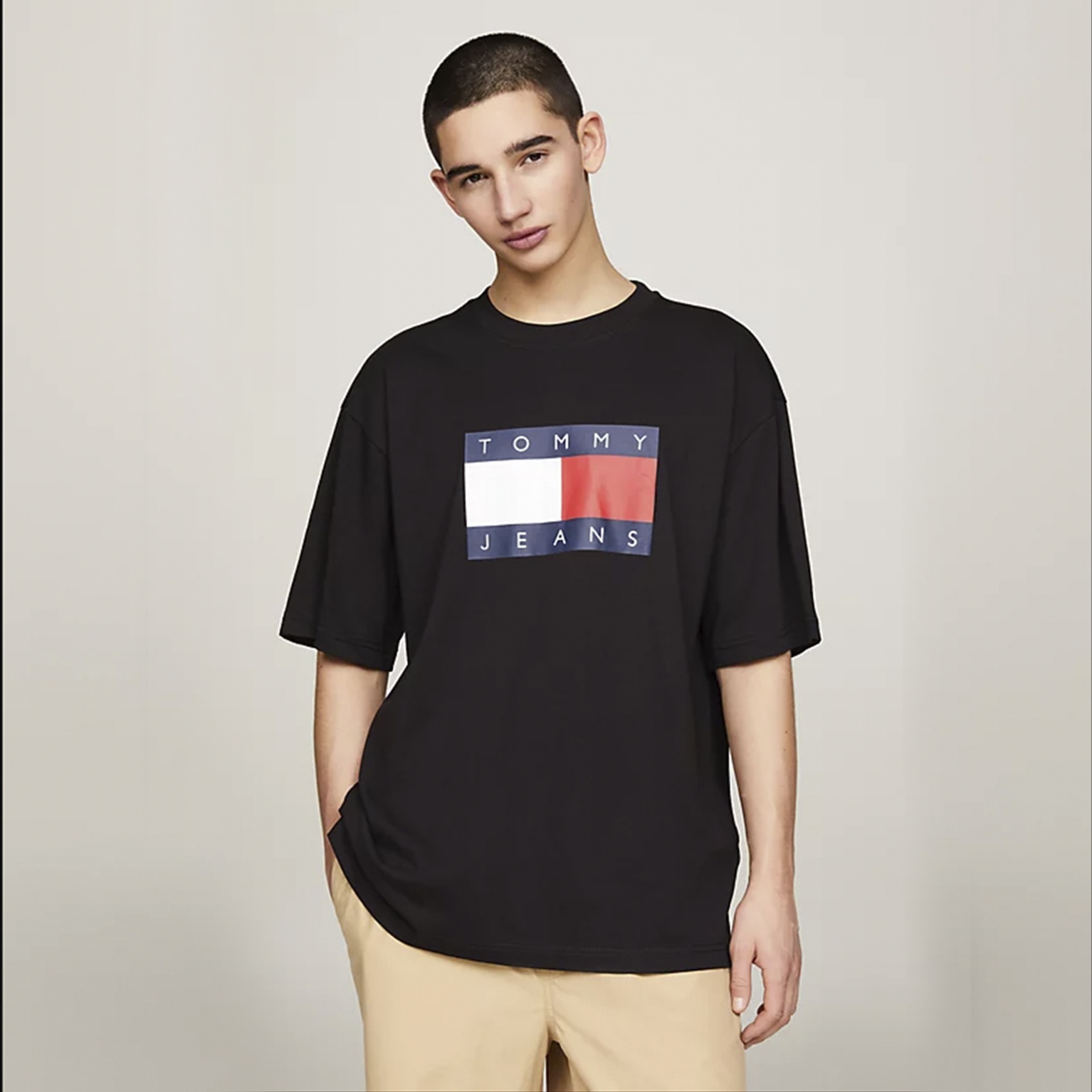 T-shirt preta com estampado Tommy Jeans no centro usada por modelo masculino