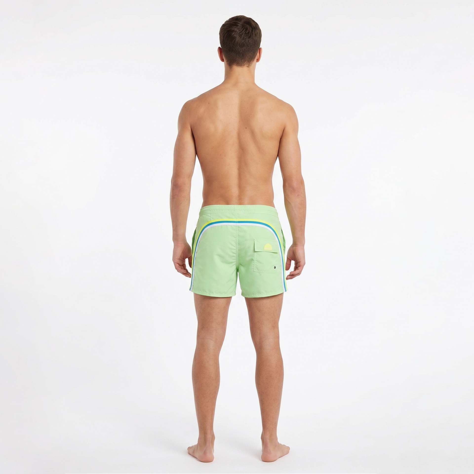 Homem de costas a usar calções de banho verdes claros com detalhes coloridos e bolso traseiro.
