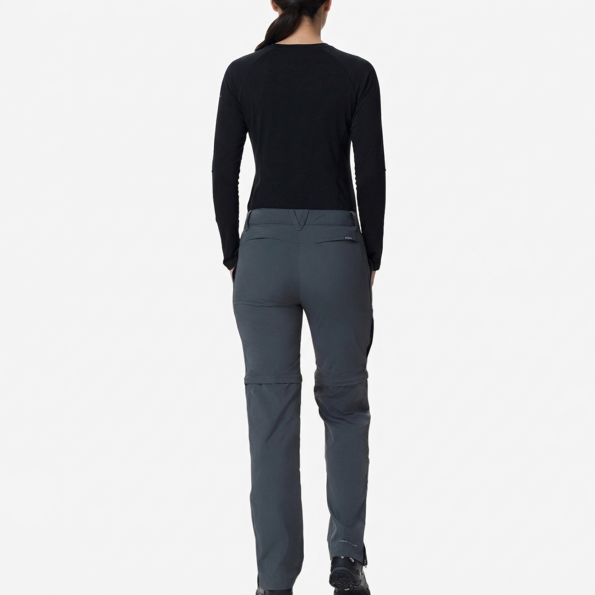 Pessoa de costas a usar calças cinza e camisola preta de manga comprida