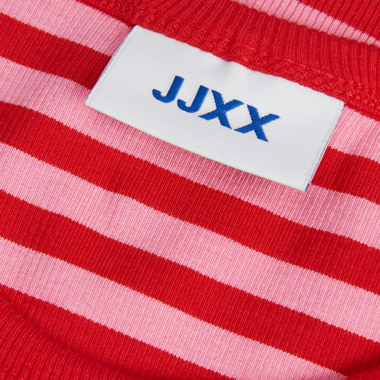 Etiqueta J.JX em tecido de malha com riscas vermelhas e rosas