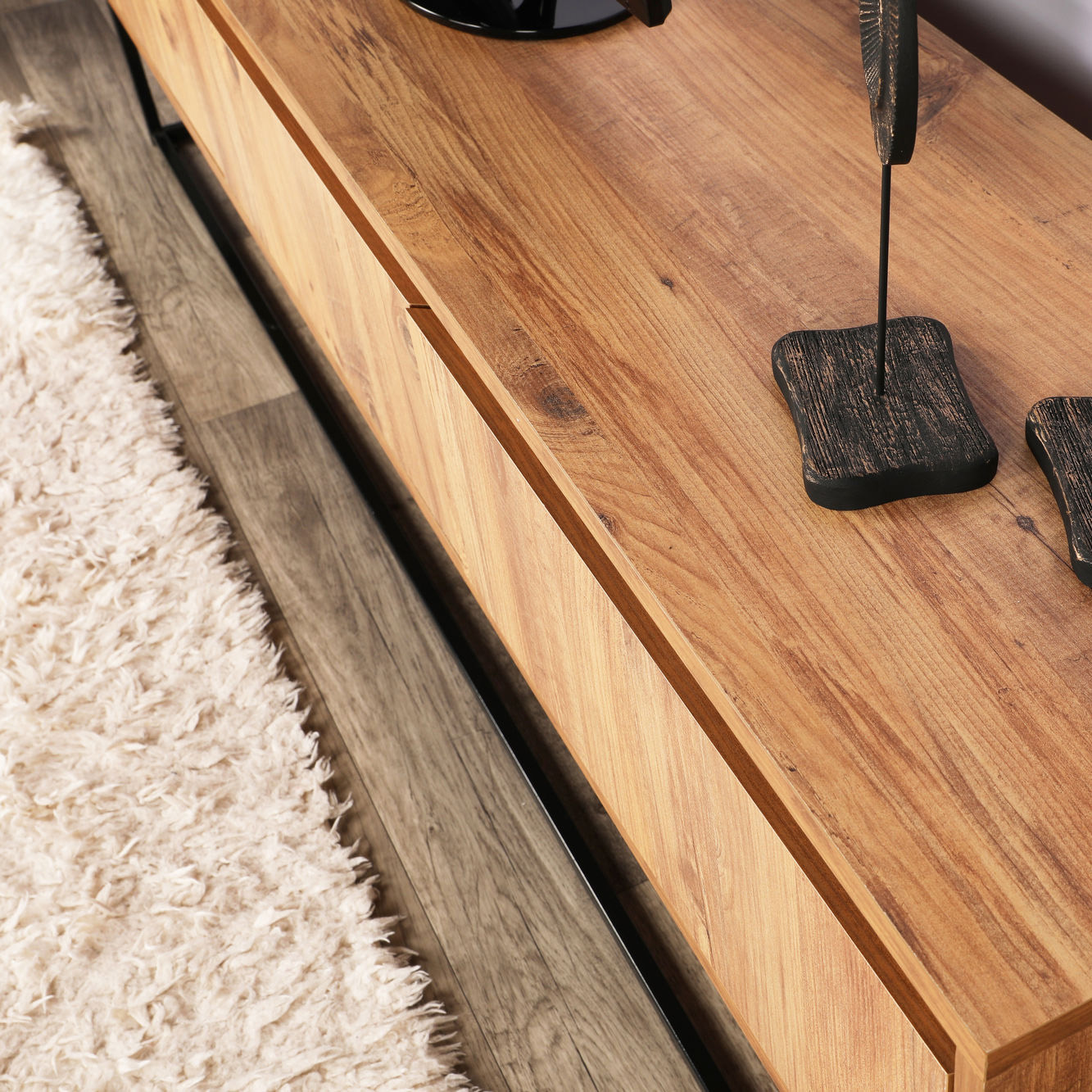 Móvel de madeira clara com tampo e bordas definidas, chão em madeira escura e tapete branco fofo