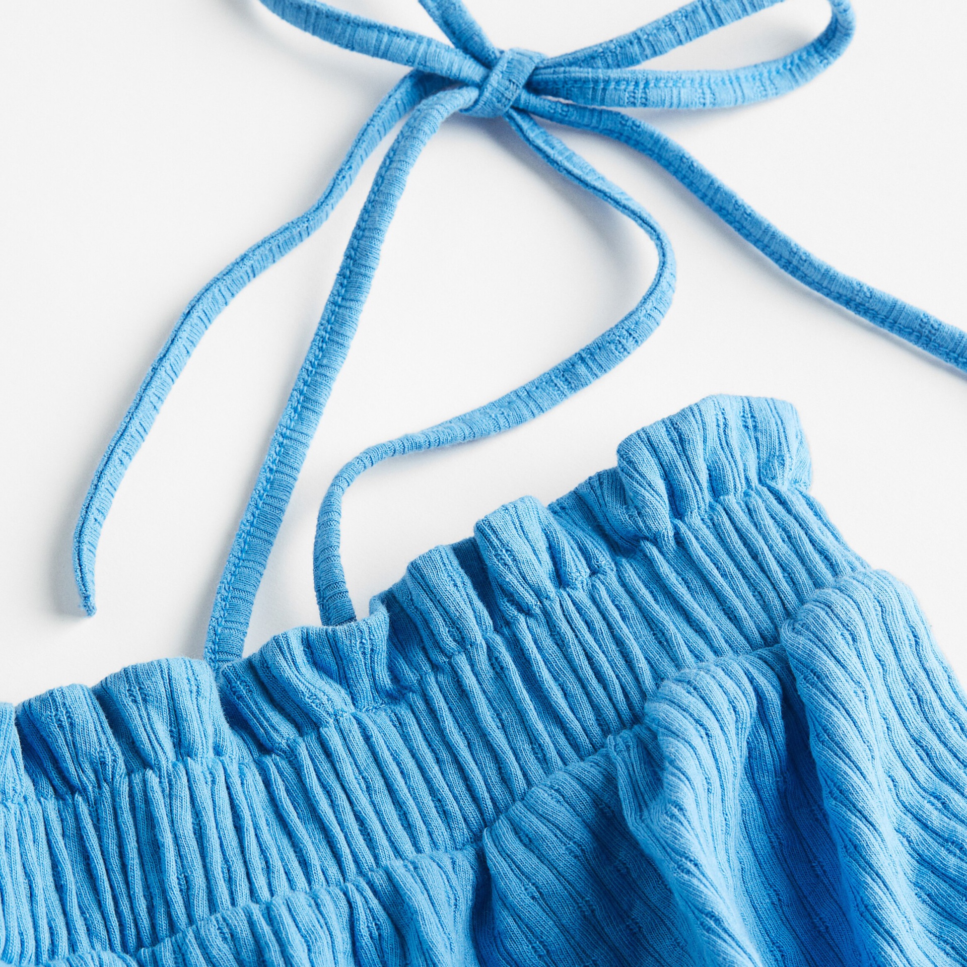 Parte superior azul claro de bikini com padrão canelado e alças finas