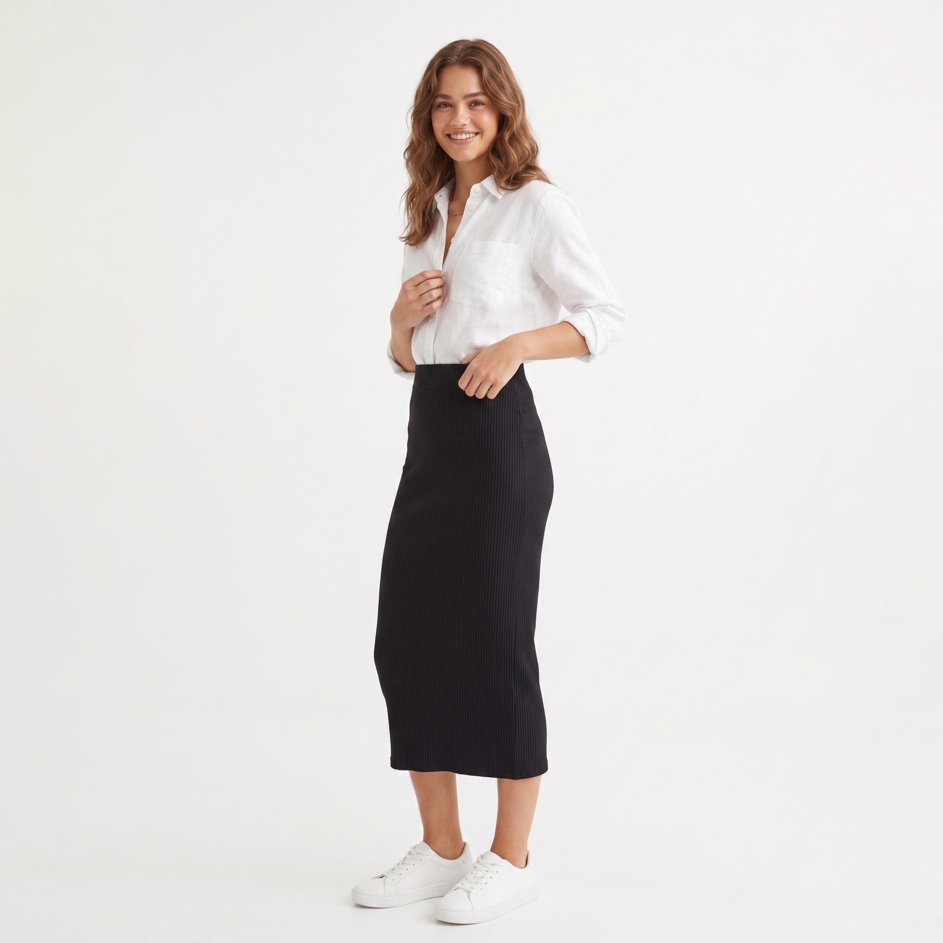 Mulher com camisa branca, saia preta e ténis brancos em fundo branco