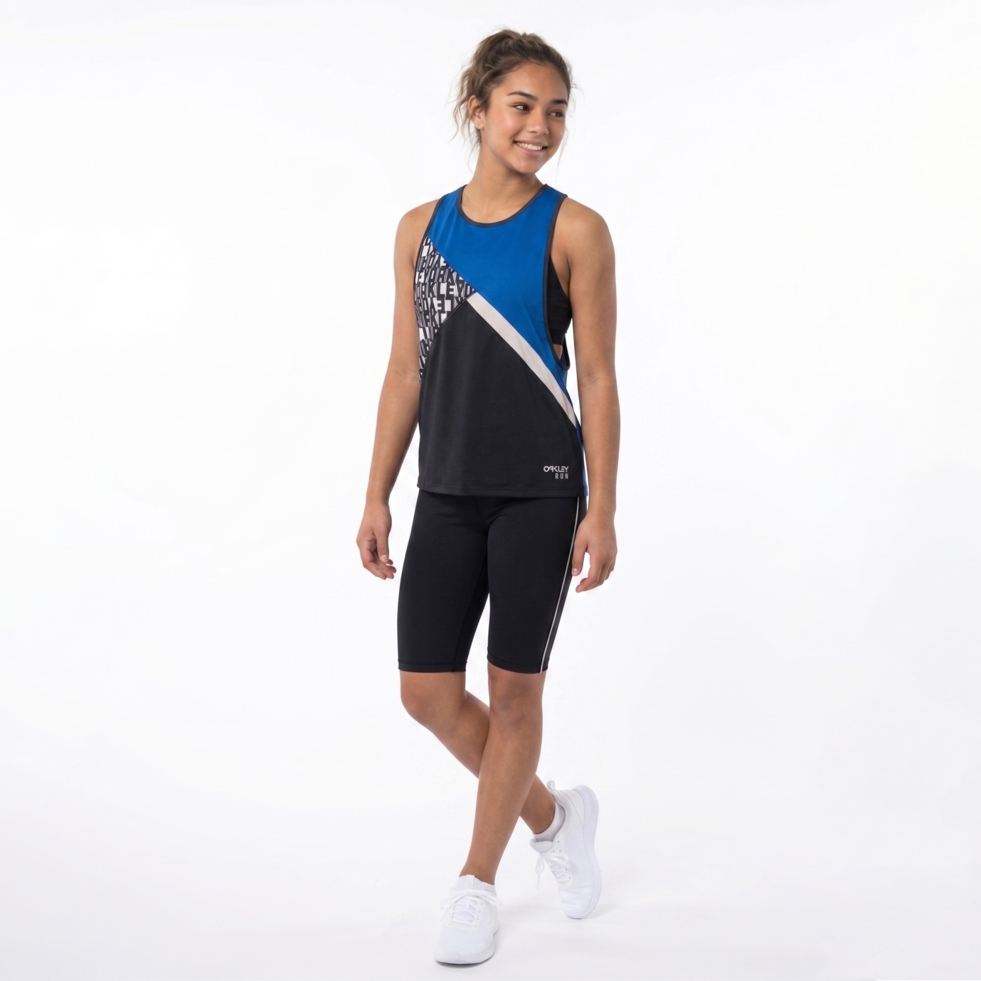 Mulher jovem com roupa desportiva preta e azul em fundo branco