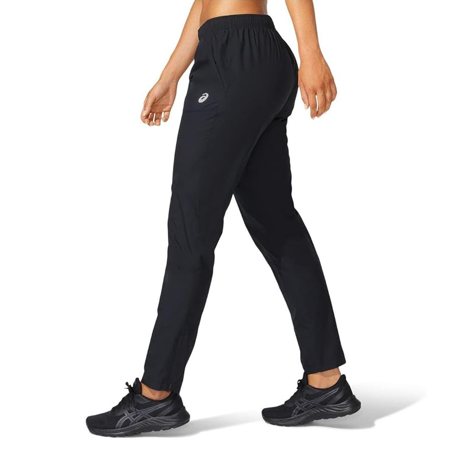 Calças desportivas pretas Asics com ténis pretos num fundo branco