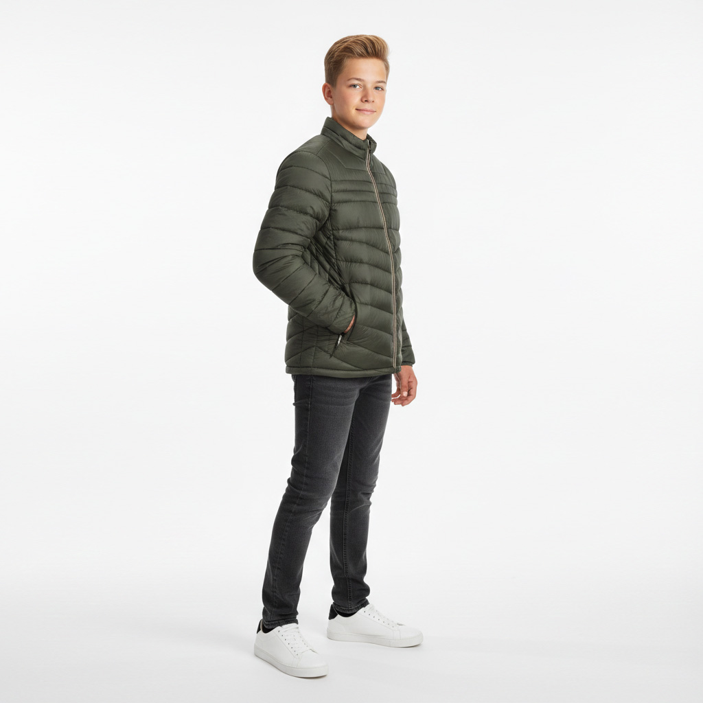 Rapaz com casaco acolchoado verde-oliva, jeans pretos e sapatos brancos em estúdio