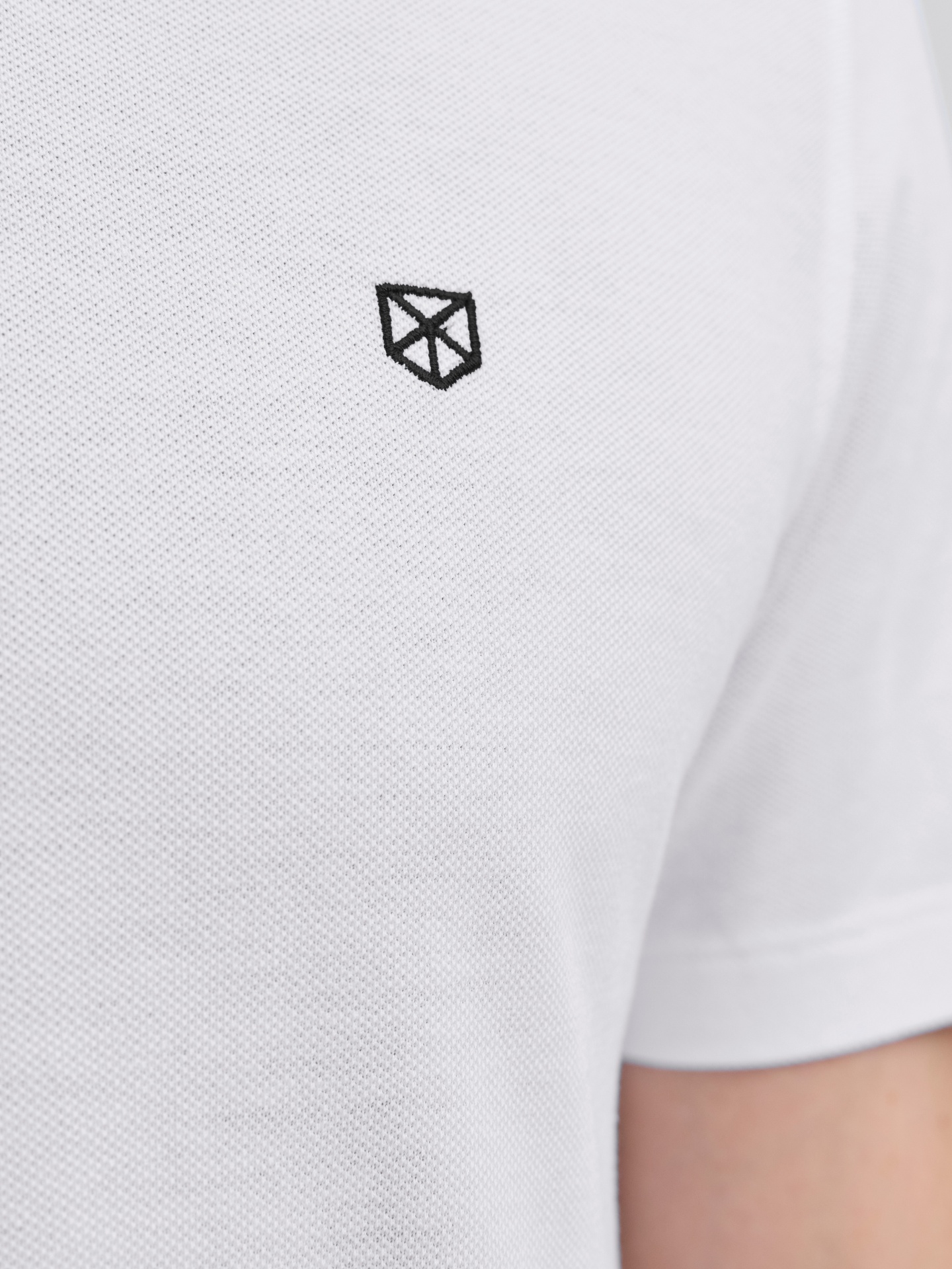 Camiseta branca com logotipo geométrico preto bordado no peito