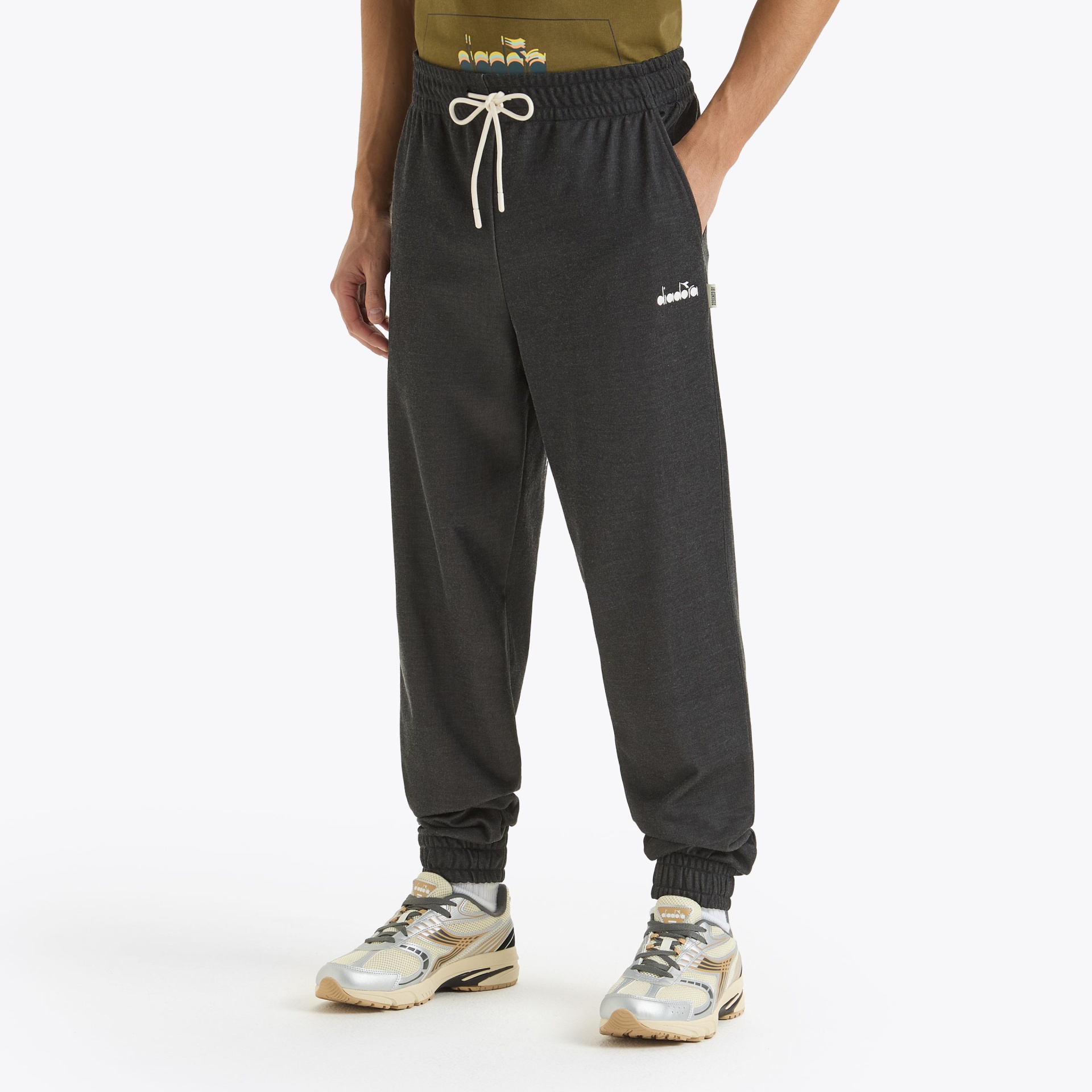 Calças de treino pretas com cordão branco usadas com sapatilhas e t-shirt