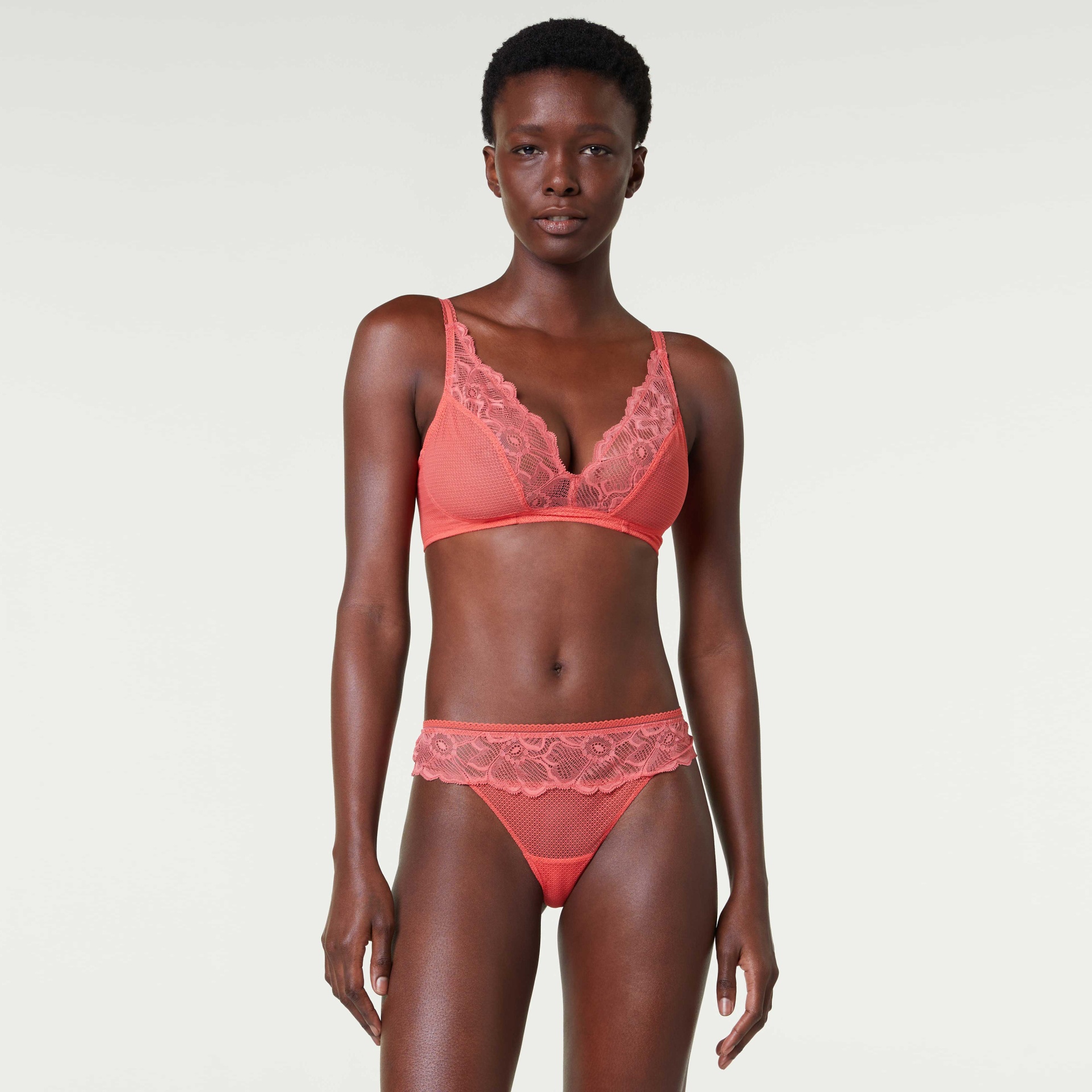 Conjunto de lingerie feminino rosa coral com renda floral e malha em fundo branco