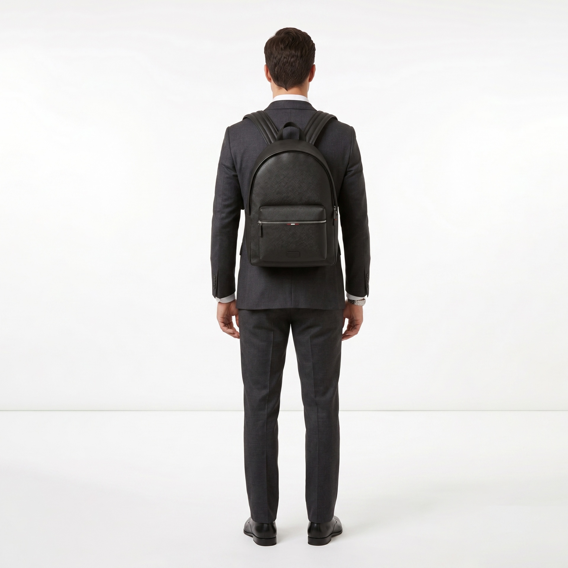 Homem de costas com mochila preta e fato cinza