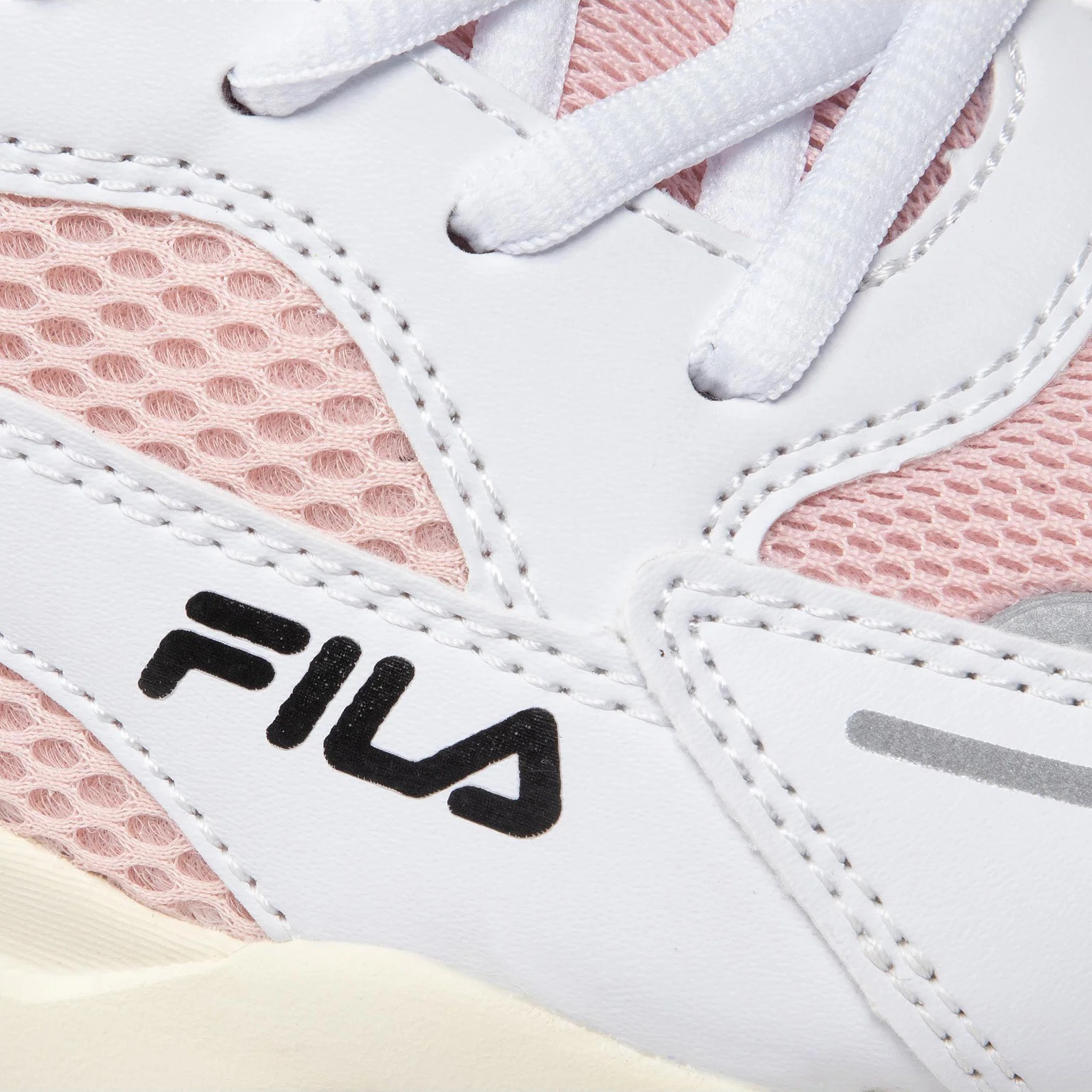Close-up de ténis FILA rosa e branco com malha e couro