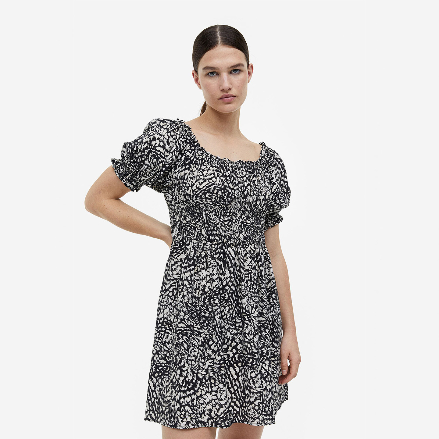 Vestido curto preto e branco com padrão abstracto com manga bufante e decote quadrado.