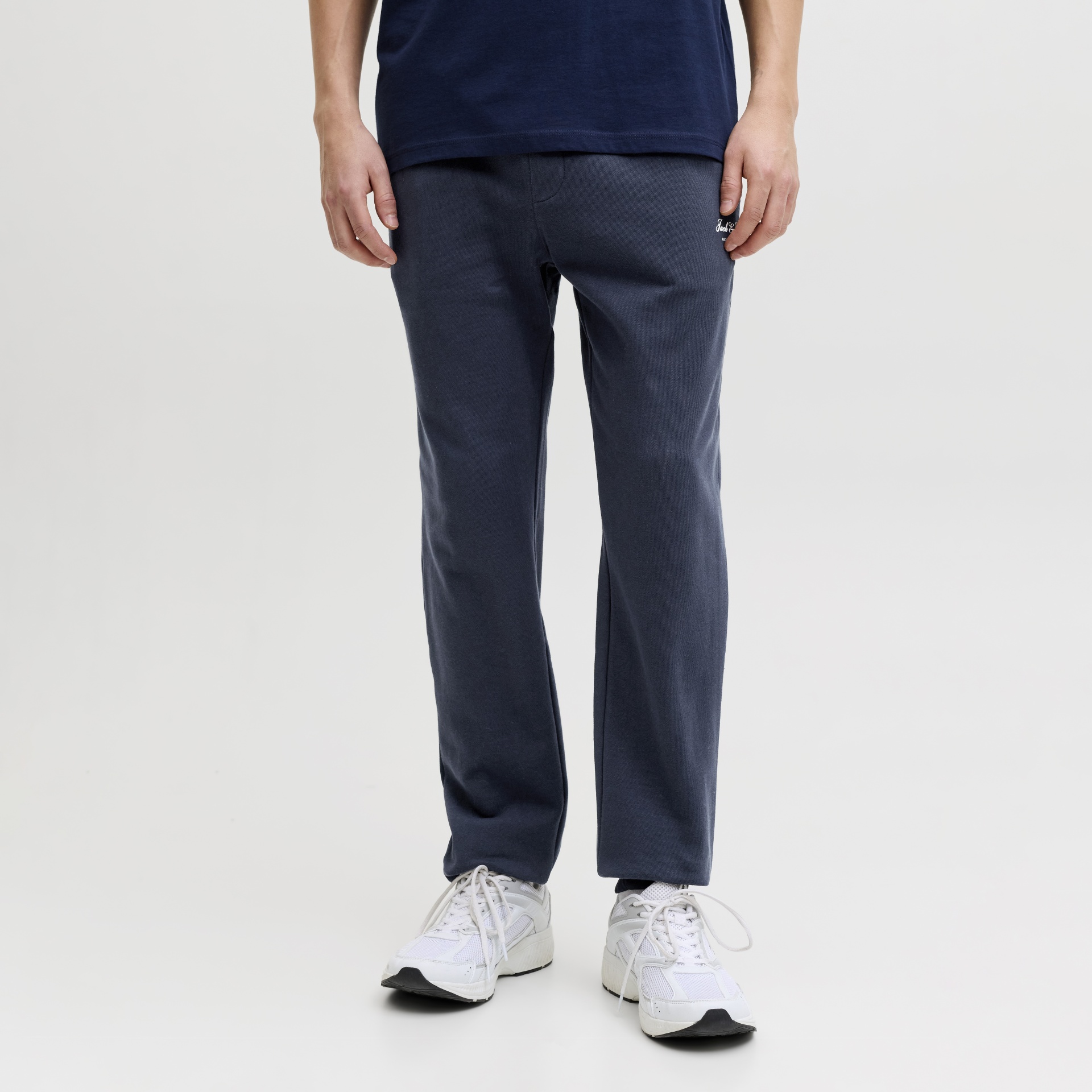 Calças azul-escuras com etiqueta Jack & Jones e ténis brancos