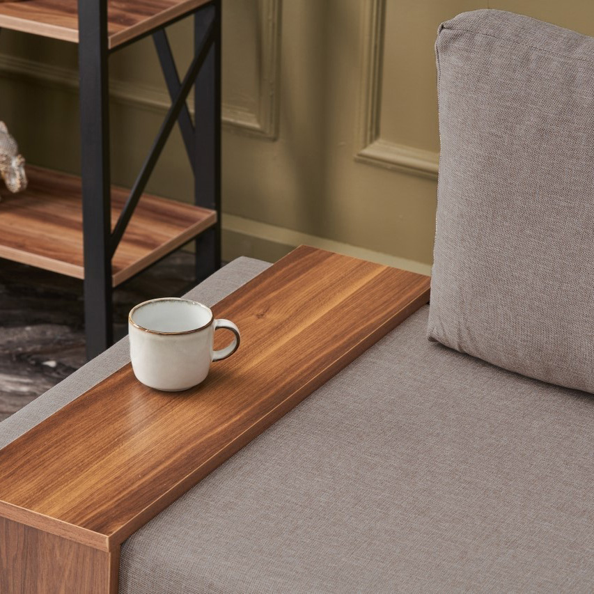 Sofá cinzento com mesa lateral de madeira e caneca branca