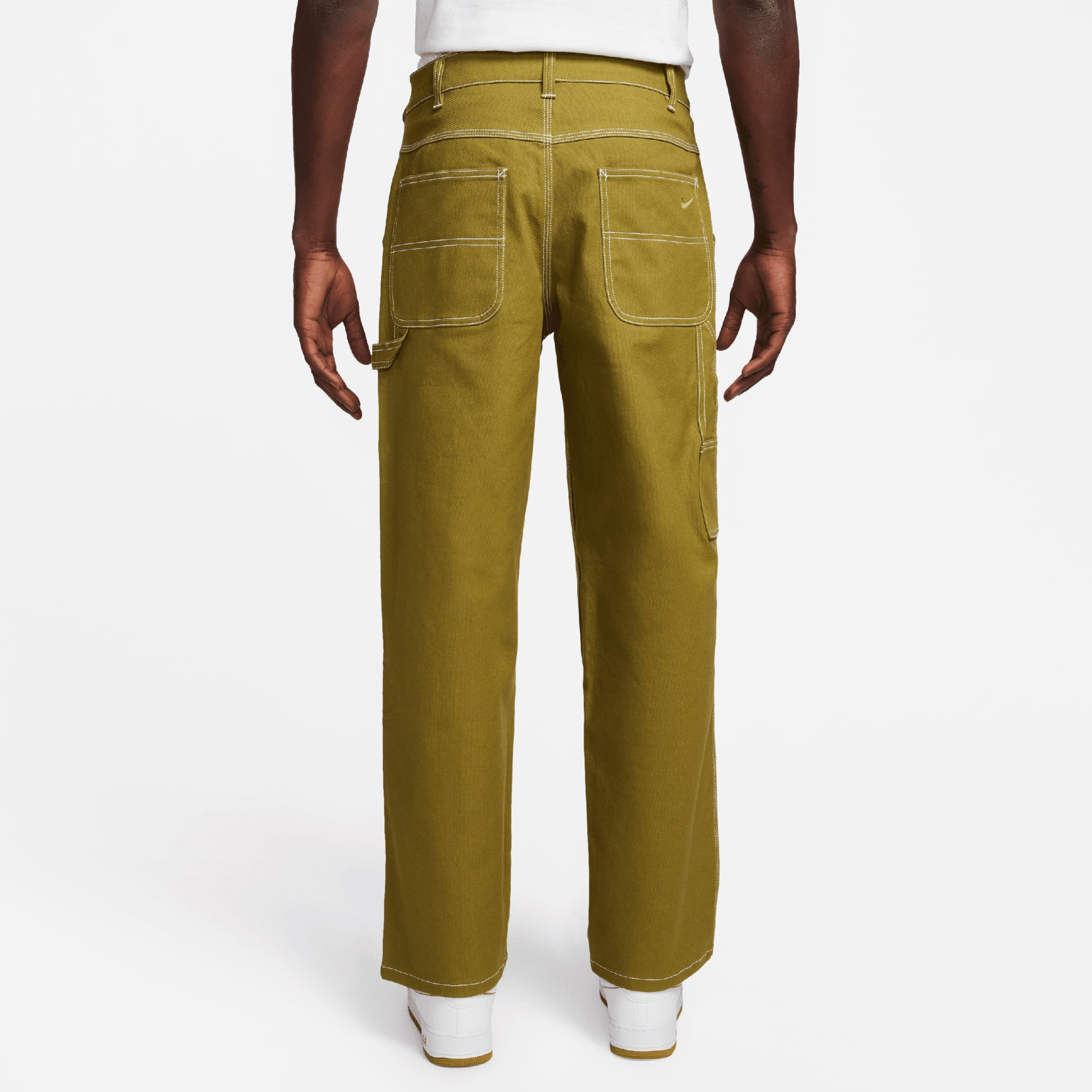 Calças verdes com costuras brancas e bolsos quadrados atrás, vista de costas