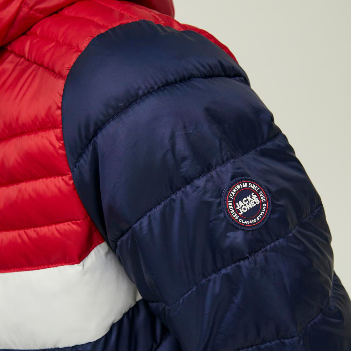 Casaco acolchoado em vermelho, branco e azul com logótipo Jack & Jones no braço