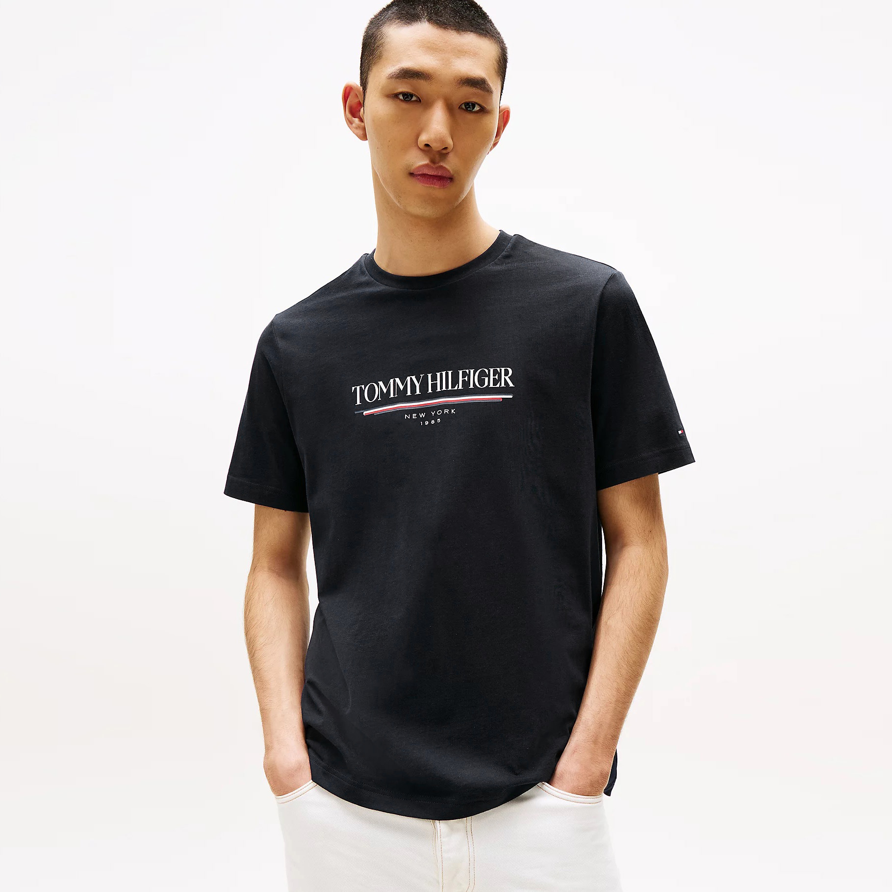 T-shirt preta Tommy Hilfiger com texto branco vista em modelo masculino