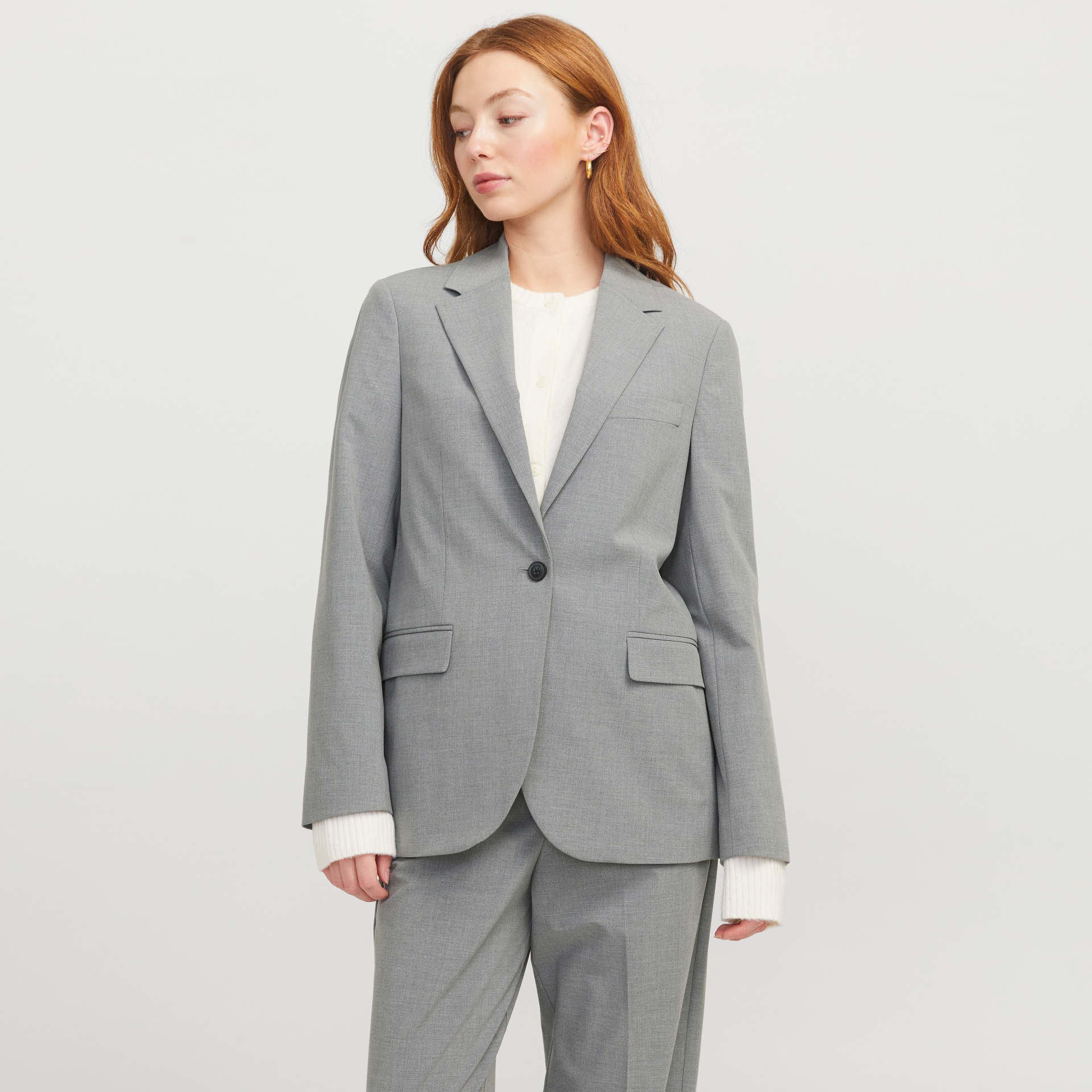 Mulher com blazer e calças cinzentas e camisola branca