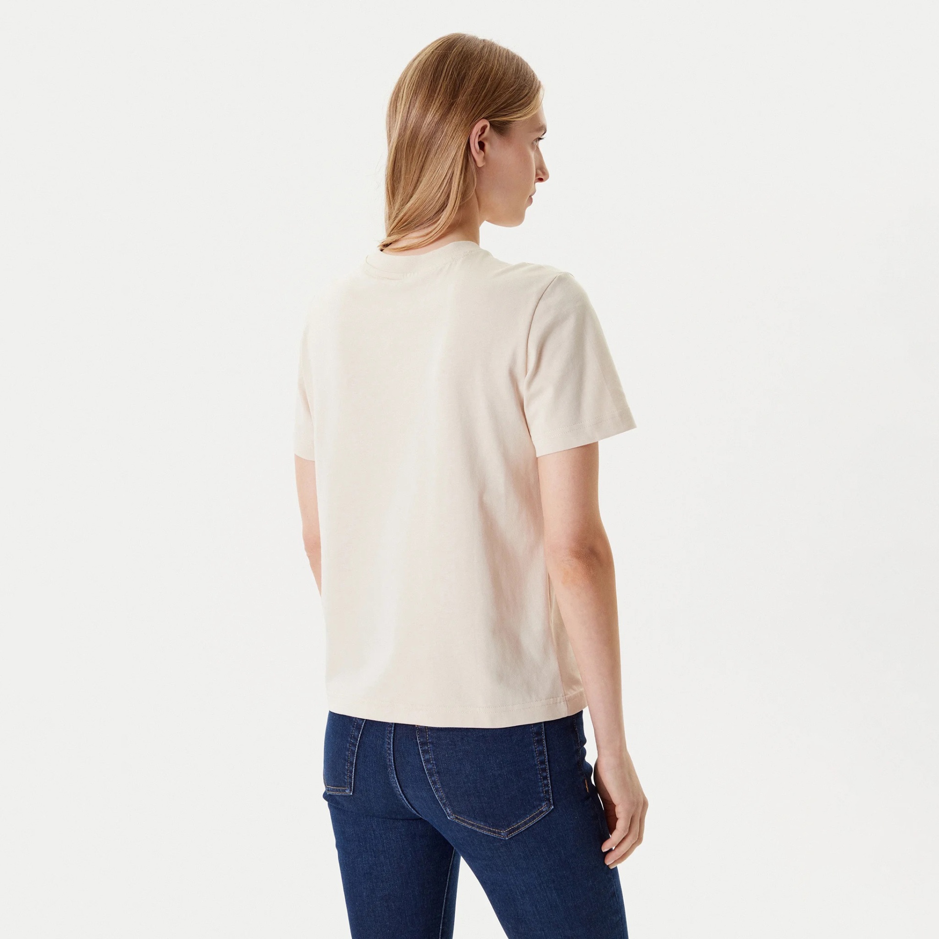 Pessoa de costas com t-shirt branca e jeans azul escuro