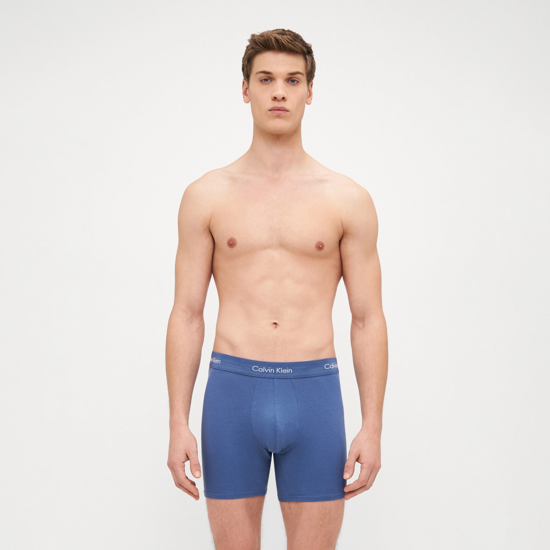 Boxers masculinos azuis com cintura elástica azul e logótipo Calvin Klein em modelo masculino.