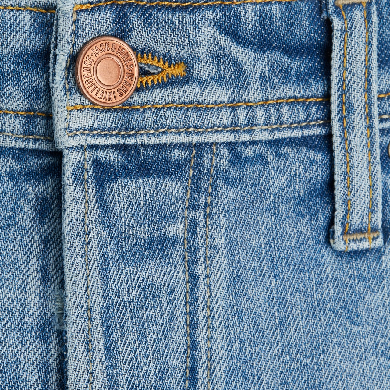 Close-up de calça de ganga azul claro com botão metálico e bolso