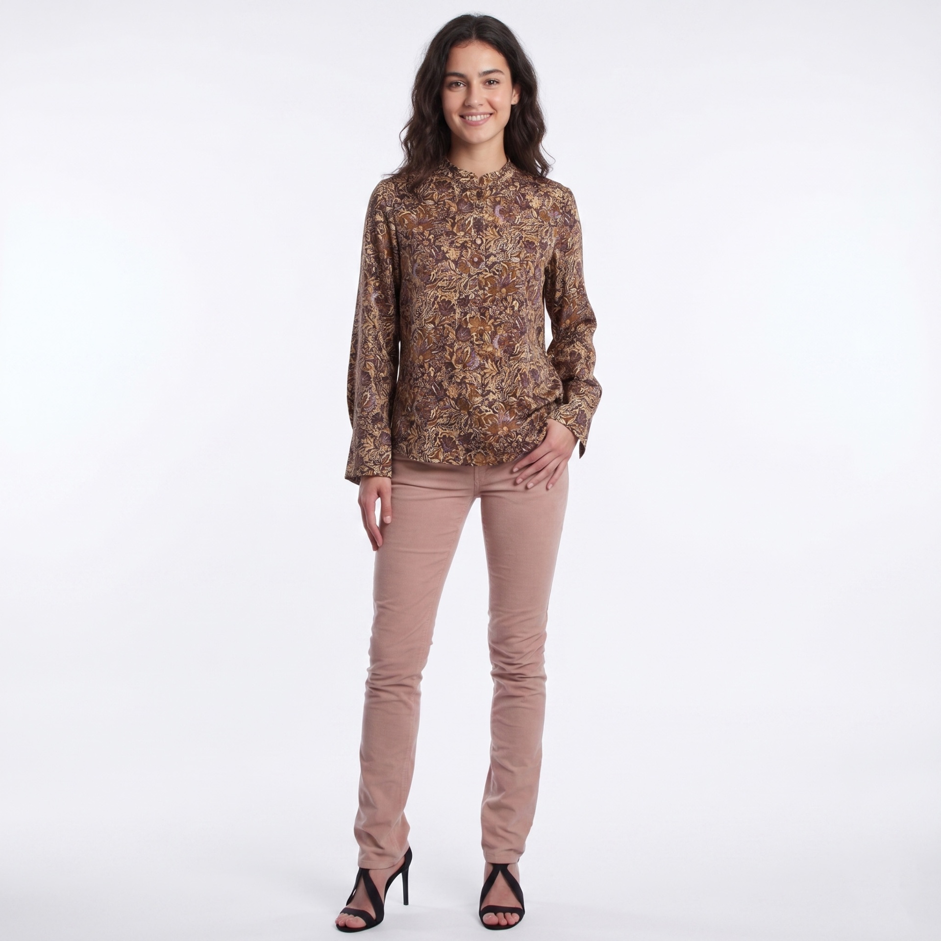 Mulher vestindo blusa floral castanha e calças rosa com sandálias pretas de salto.