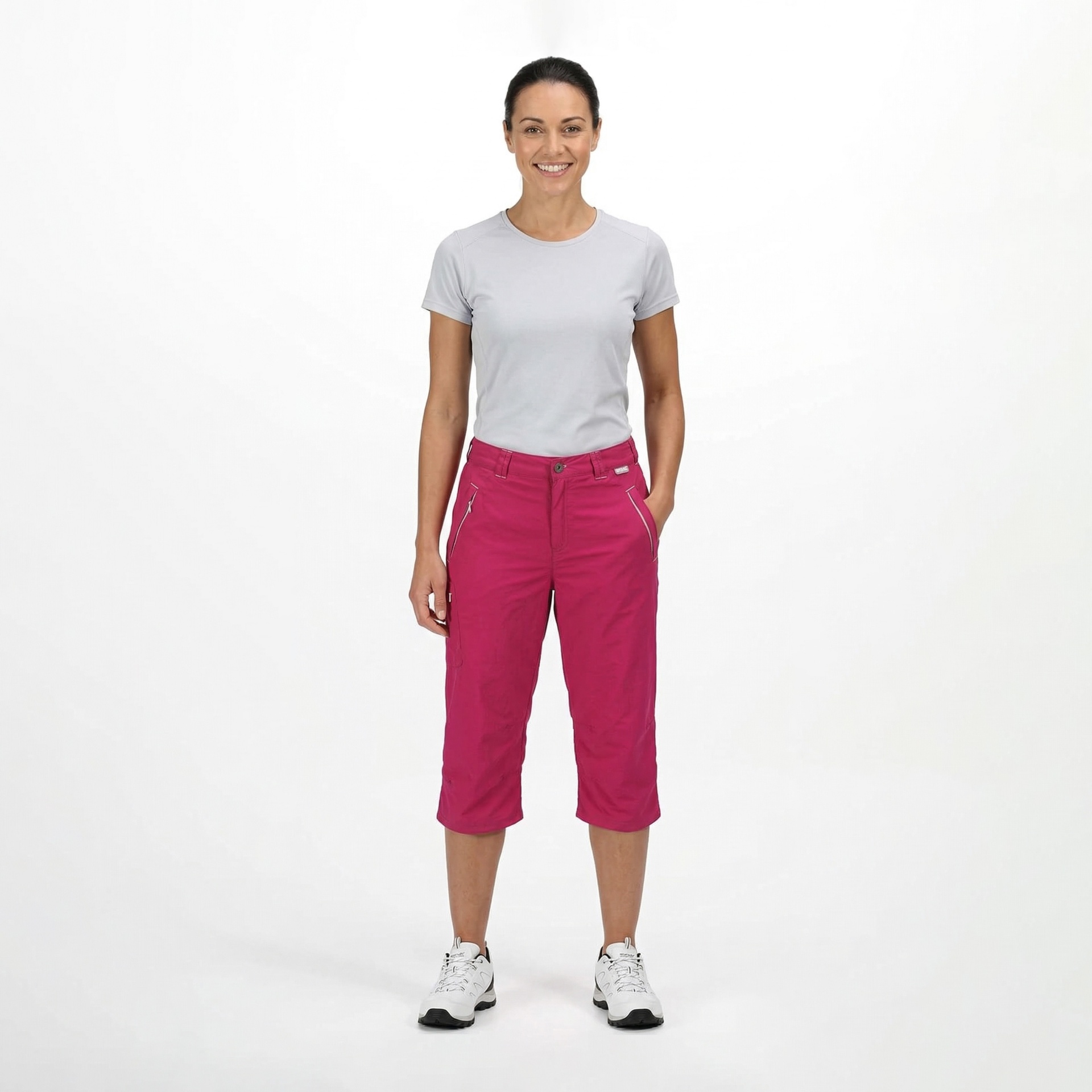 Mulher com tshirt cinza clara e calças capri rosa e ténis brancos