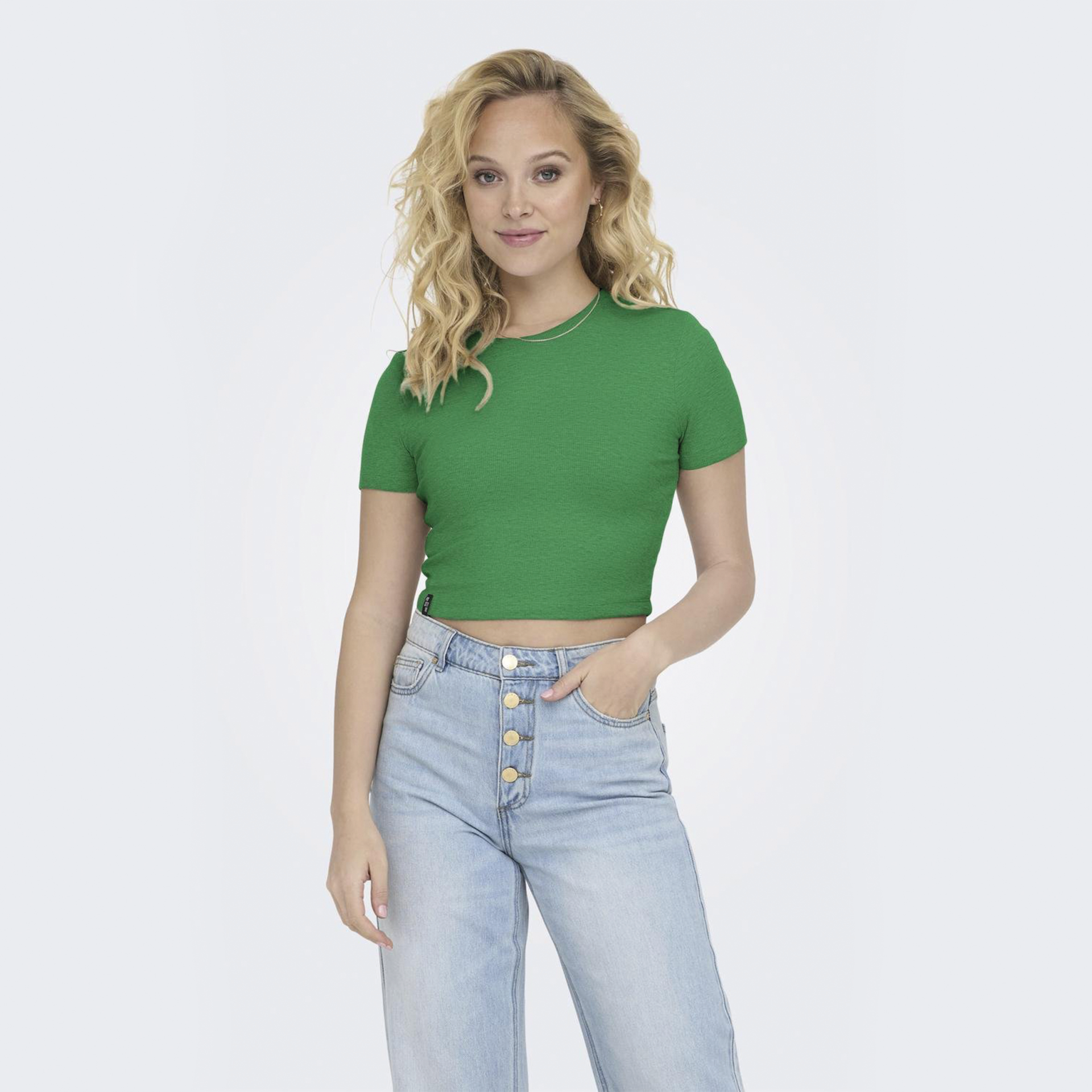 Mulher com camiseta verde curta e calças de ganga azul claro