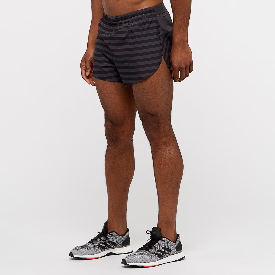 Calções desportivos pretos com riscas horizontais usados por homem