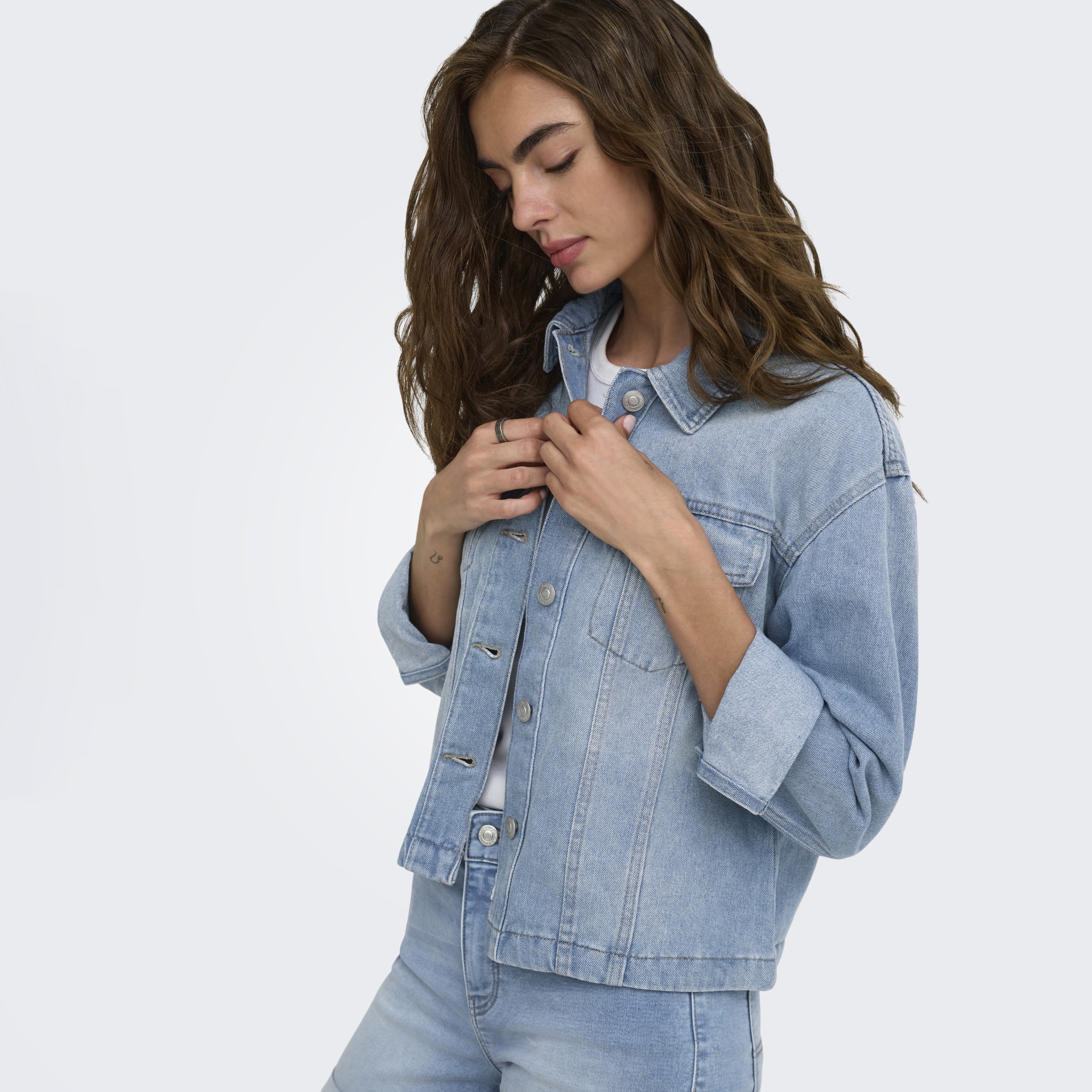 Casaco de ganga azul claro com botões metálicos e jeans azul clara