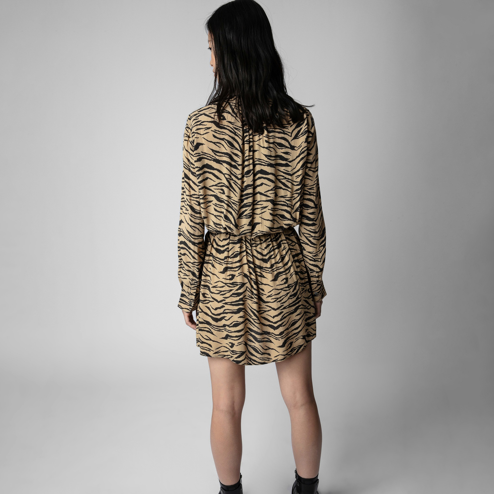 Vestido curto com padrão animal bege e preto visto pelas costas